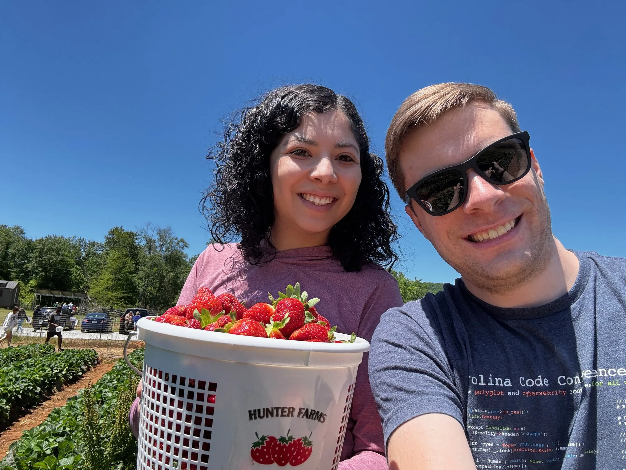 Dylan and Letica smiling beside a basket of strawberries